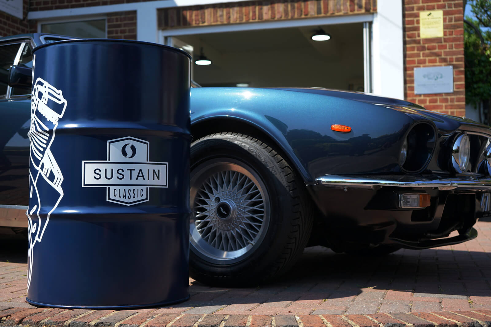 A SUSTAIN Classic drum, next to a car on the brick drive of a home